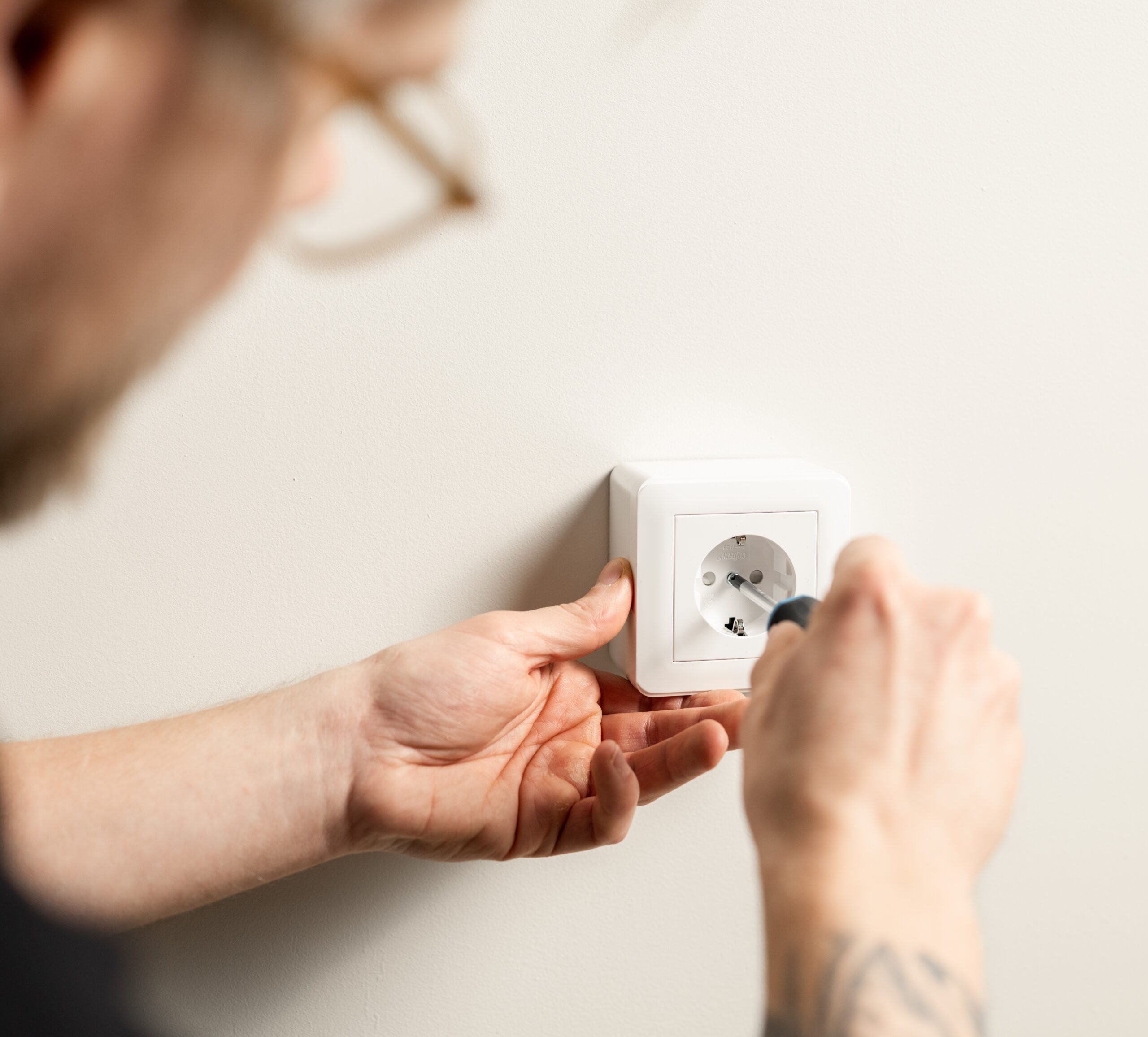 Elektriker från Clas Fixares som installerar ett vägguttag.